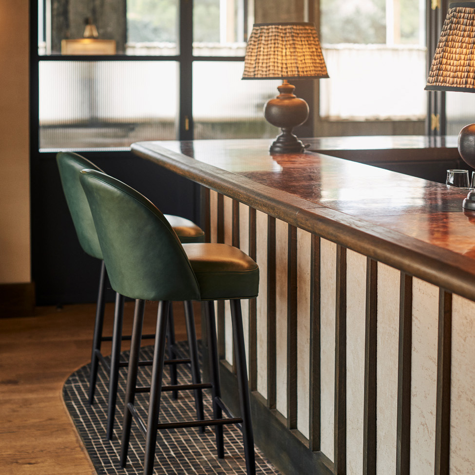 Bar front with green leather stools at The Gallivant Hotel