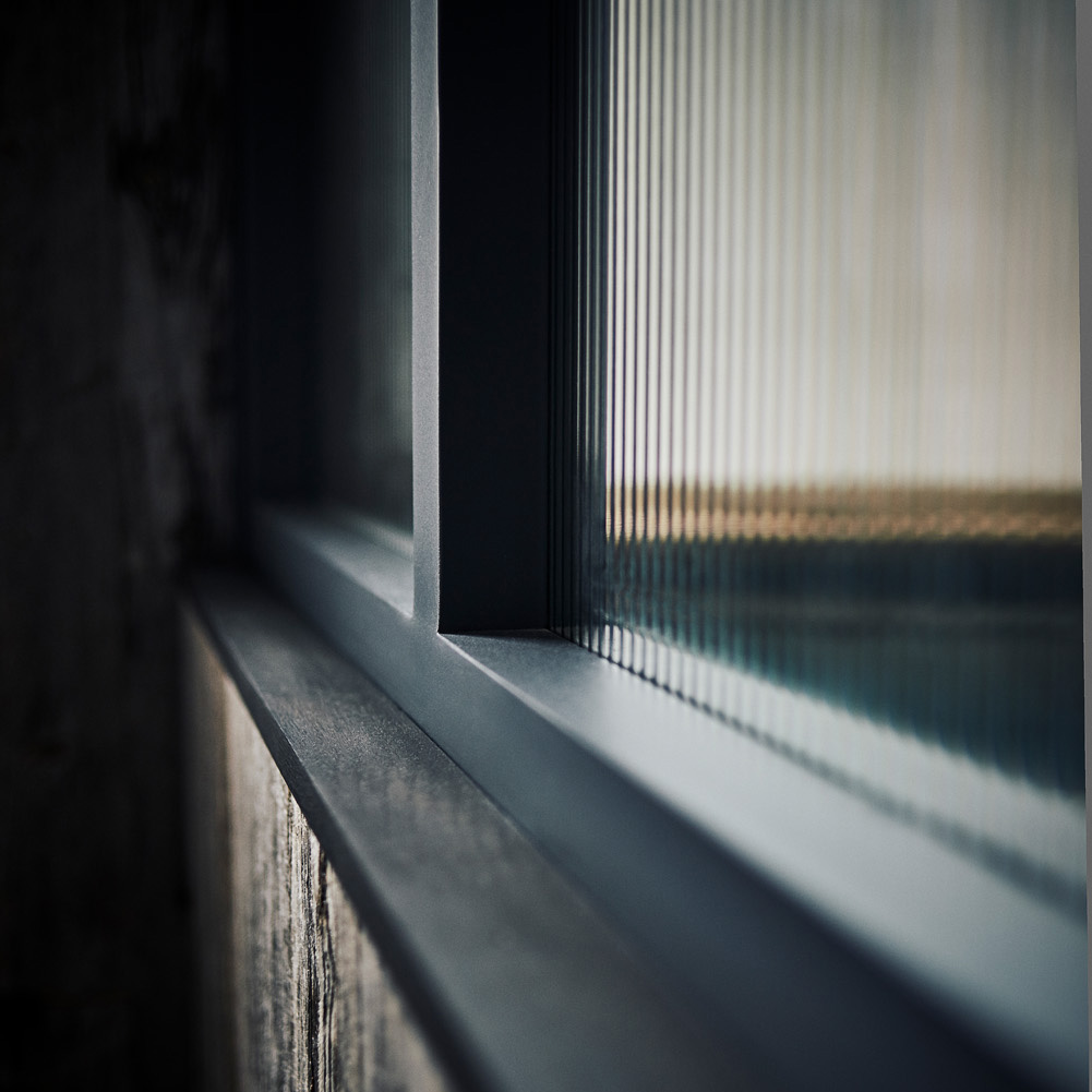 Close up view of the black and reeded glass window pane in the private dining room of The Gallivant Hotel