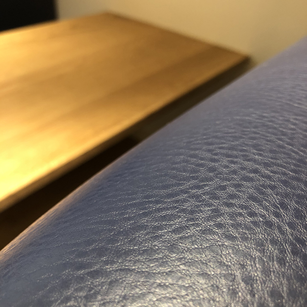 close up of blue leather upholstered booth seating