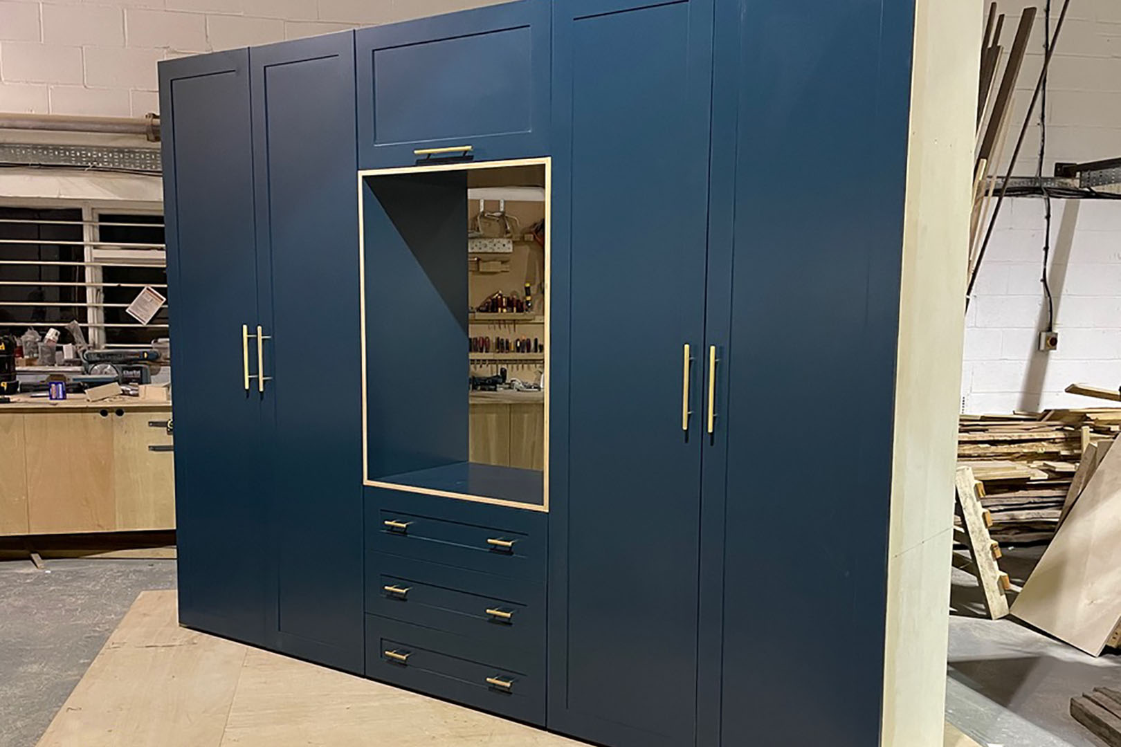 made to measure bedroom furniture, dark blue wardrobes and drawers with brass handles