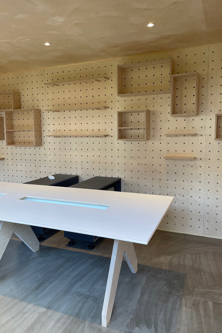 plywood interior of the garden office with pegboard wall and pegboxes