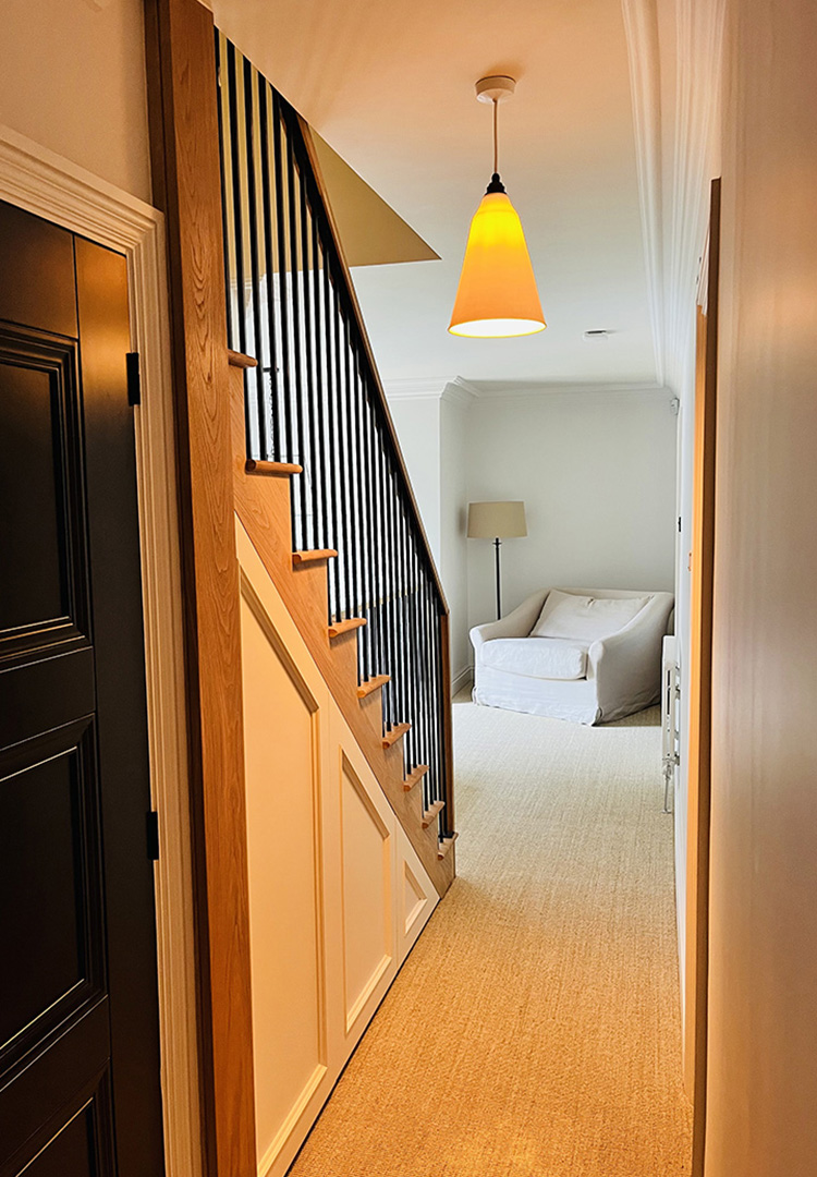 bedroom view of oak staircase with black steel balustrade and oak handrail