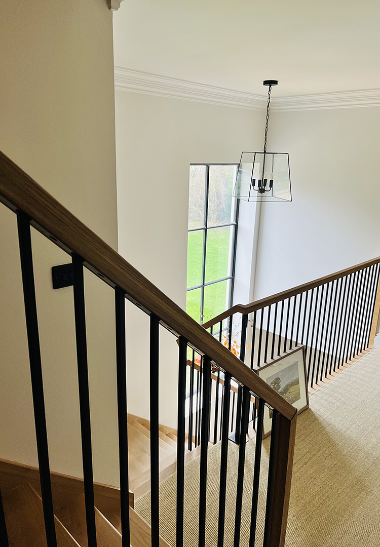 close up view of oak staircase with black steel balustrade and oak handrail