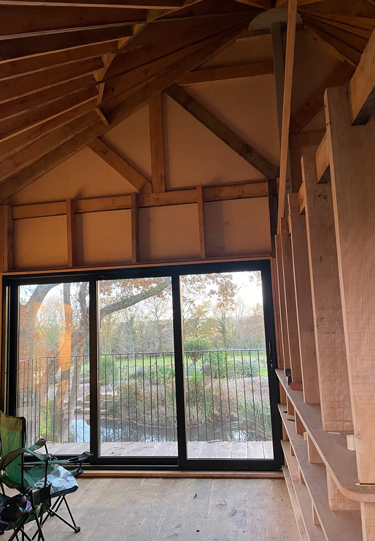 internal view of the luxury treehouse, looking out through the black glazed doors