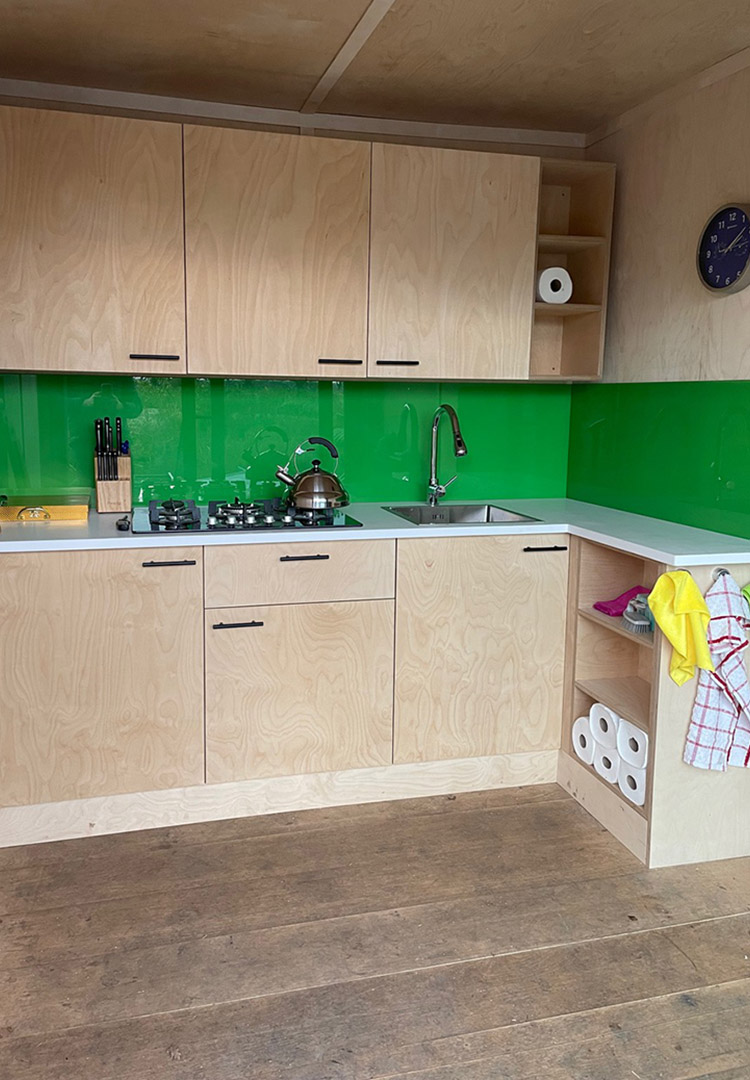 Birch Plywood kitchen with a bright green splashback in the luxury treehouse