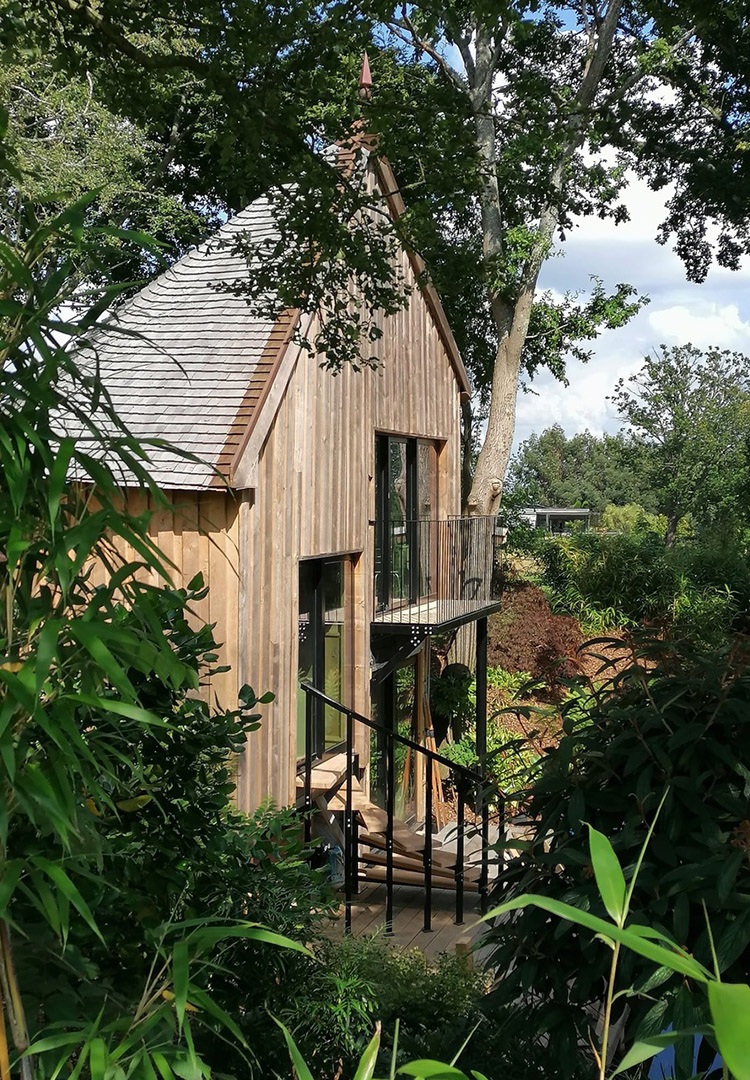 Luxury treehouse with a round Oak shingle roof nestled amongst the trees
