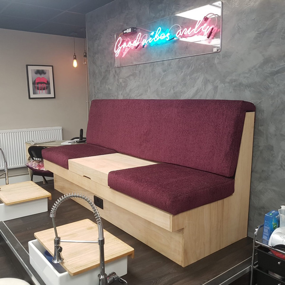 A bespoke beauty treatment sofa made from wood and maroon upholstery