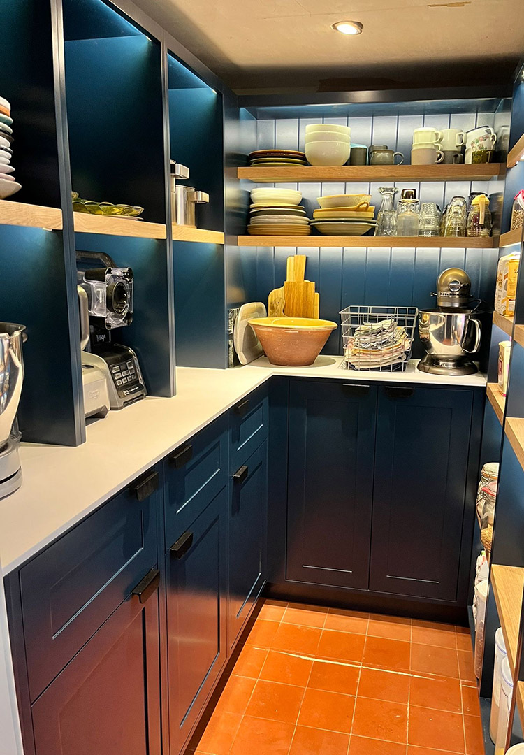 dark blue kitchen pantry with shaker cupboards, white HiMacs worktop and illuminated oak shelves