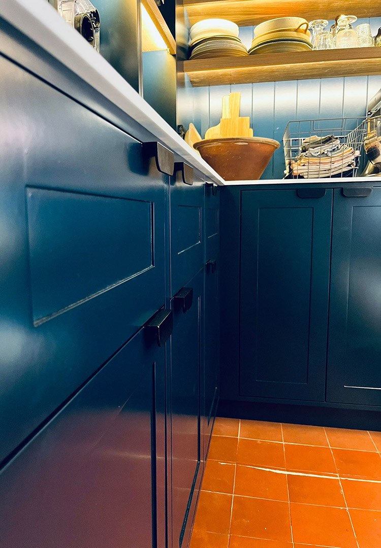 close up view of dark blue painted shaker drawers in the kitchen pantry