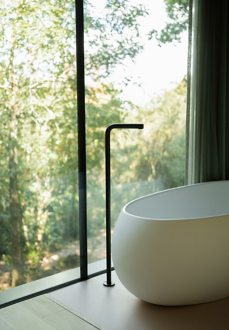 close view of the egg shaped bathtub at looking glass lodge with a view into the woodland