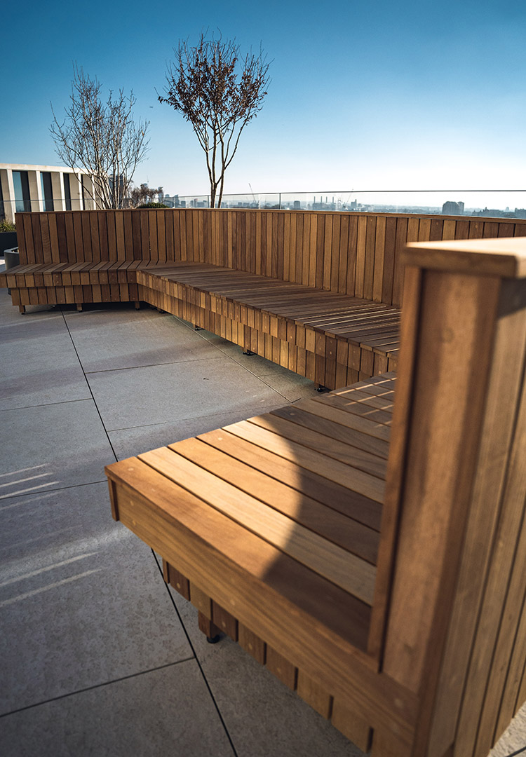 Curved end of a bespoke Iroko bench, Luxury outdoor furniture on a London terrace